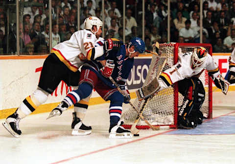 RANGERS FORWARD STEVE LARMER IS MANHANDLED BY CANUCKS DEFENSEMAN JYRKI LUMME