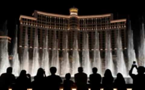 LAS VEGAS, NEVADA – MAY 31: Visitors are silhouetted as they watch The Fountains of Bellagio on May 31, 2021 in Las Vegas, Nevada. Clark County is dropping all pandemic mandates as its COVID-19 mitigation plan expires at midnight on June 1, meaning businesses may operate at 100 percent capacity with no physical distancing restrictions. (Photo by Ethan Miller/Getty Images)