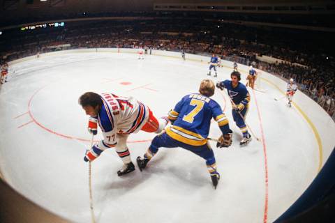 NEW YORK – 1979: New York Rangers Phil Esposito #77 skates into the corner against St. Louis Blues Gary Unger #7 during a 1979 game at Madison Square Garden in New York, New York. (Photo by Focus on Sport/Getty Images)