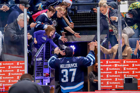 WINNIPEG, MB – DECEMBER 9: Goaltender Connor Hellebuyck #37 of the Winnipeg Jets high fives fans as he leaves the ice after receiving first star honours in a 7-1 victory over the Philadelphia Flyers at the Bell MTS Place on December 9, 2018 in Winnipeg, Manitoba, Canada. (Photo by Darcy Finley/NHLI via Getty Images)