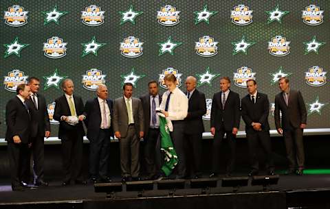 Jun 27, 2014; Philadelphia, PA, USA; Julius Honka prepares to put on a team sweater in front of team officials after being selected as the number fourteen overall pick to the Dallas Stars in the first round of the 2014 NHL Draft at Wells Fargo Center. Mandatory Credit: Bill Streicher-USA TODAY Sports