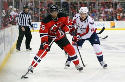 Mar 25, 2016; Newark, NJ, USA; New Jersey Devils right wing Devante Smith-Pelly (25) skates with the puck while being defended by Washington Capitals center Nicklas Backstrom (19) during the second period at Prudential Center. Mandatory Credit: Ed Mulholland-USA TODAY Sports