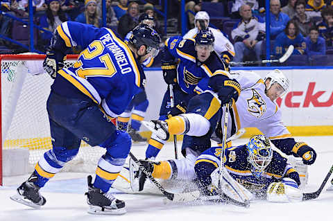 Dec 30, 2016; St. Louis, MO, USA; Nashville Predators left wing Colin Wilson (33) falls over St. Louis Blues goalie Carter Hutton (40) as defenseman Alex Pietrangelo (27) clears the puck during the third period at Scottrade Center. The Predators won 4-0. Mandatory Credit: Jeff Curry-USA TODAY Sports