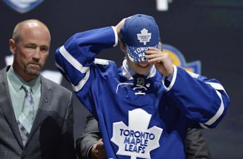 Jun 26, 2015; Sunrise, FL, USA; Mitchell Marner puts on a team cap after being selected as the number four overall pick to the Toronto Maple Leafs in the first round of the 2015 NHL Draft at BB&T Center. Mandatory Credit: Steve Mitchell-USA TODAY Sports