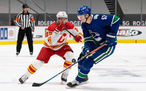 Tyler Myers of the Vancouver Canucks defends against Elias Lindholm of the Calgary Flames (Photo by Rich Lam/Getty Images).