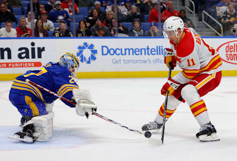 Oct 19, 2023; Buffalo, New York, USA; Buffalo Sabres goaltender Devon Levi (27) knocks the puck off the stick of Calgary Flames center Mikael Backlund (11) as he skates in on a breakaway during the third period at KeyBank Center. Mandatory Credit: Timothy T. Ludwig-USA TODAY Sports