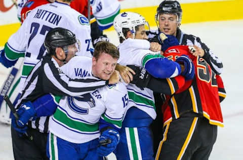 Oct 7, 2015; Calgary, Alberta, CAN; Vancouver Canucks right wing Derek Dorsett (15) and defenseman Luca Sbisa (5) and Calgary Flames left wing Brandon Bollig (52) are separated during the third period at Scotiabank Saddledome. Vancouver Canucks won 5-1. Mandatory Credit: Sergei Belski-USA TODAY Sports