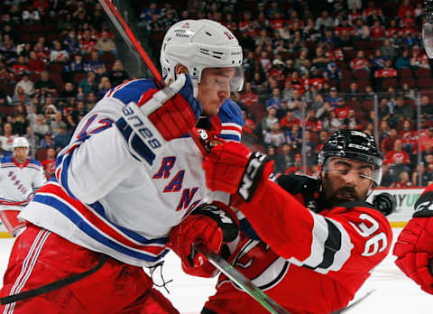 NEWARK, NEW JERSEY – SEPTEMBER 30: Julien Gauthier #12 of the New York Rangers hits Joseph Gambardella #36 of the New Jersey Devils during the first period at the Prudential Center on September 30, 2022, in Newark, New Jersey. (Photo by Bruce Bennett/Getty Images)