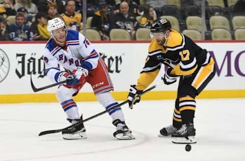 PITTSBURGH, PA – DECEMBER 20: Jonny Brodzinski, #76 of the New York Rangers, passes the puck as Bryan Rust #17 of the Pittsburgh Penguins defends in the third period during the game at PPG PAINTS Arena on December 20, 2022, in Pittsburgh, Pennsylvania. (Photo by Justin Berl/Getty Images)