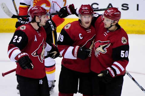 Feb 12, 2016; Glendale, AZ, USA; Arizona Coyotes right wing Shane Doan (19) celebrates with defenseman Oliver Ekman-Larsson (23) and center Antoine Vermette (50) after scoring a goal in the third period against the Calgary Flames at Gila River Arena. Mandatory Credit: Matt Kartozian-USA TODAY Sports