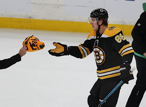 BOSTON – NOVEMBER 10: Boston Bruins’ David Pastrnak picks out one of the hats thrown on to the ice after he scored a third period goal for a hat-trick. The Boston Bruins host the Toronto Maple Leafs in a regular season NHL hockey game at TD Garden in Boston on Nov. 10, 2018. (Photo by John Tlumacki/The Boston Globe via Getty Images)