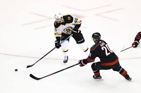 David Krejci #46 of the Boston Bruins is defended by Sebastian Aho #20 of the Carolina Hurricanes (Photo by Elsa/Getty Images)