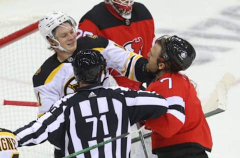 Jan 14, 2021; Newark, New Jersey, USA; Boston Bruins center Trent Frederic (11) and New Jersey Devils defenseman Matt Tennyson (7) push and shove during the second period at Prudential Center. Mandatory Credit: Ed Mulholland-USA TODAY Sports