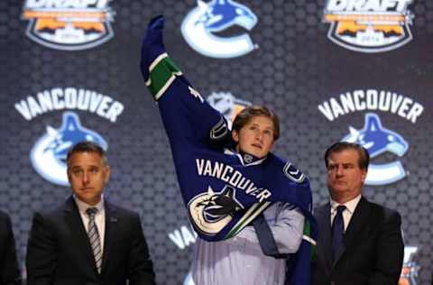 Jun 27, 2014; Philadelphia, PA, USA; Jared McCann puts on a team sweater after being selected as the number twenty-four overall pick to the Vancouver Canucks in the first round of the 2014 NHL Draft at Wells Fargo Center. Mandatory Credit: Bill Streicher-USA TODAY Sports