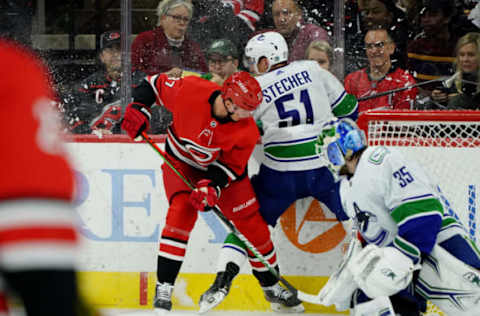 RALEIGH, NC – FEBRUARY 2: Andrei Svechnikov #37 of the Carolina Hurricanes checks Troy Stecher #51 of the Vancouver Canucks into the boards during an NHL game on February 2, 2020 at PNC Arena in Raleigh, North Carolina. (Photo by Gregg Forwerck/NHLI via Getty Images)