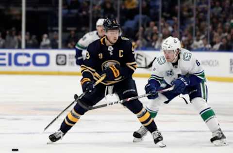 BUFFALO, NY – JANUARY 11: Jack Eichel #9 of the Buffalo Sabres skates the puck with Brock Boeser #6 of the Vancouver Canucks applying pressure during the second period of the NHL hockey game between the Vancouver Canucks and Buffalo Sabres at KeyBank Center on January 11, 2020 in Buffalo, New York. (Photo by Nicholas T. LoVerde/Getty Images)