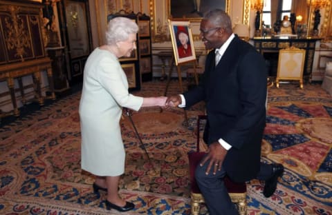 Queen Elizabeth II shakes hands after knighting Sir Rodney Williams in 2014.