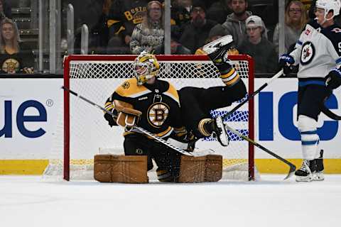 BOSTON, MASSACHUSETTS – DECEMBER 22: Jake DeBrusk #74 of the Boston Bruins crashes into the net behind Jeremy Swayman #1 during the third period of a game against the Winnipeg Jets at the TD Garden on December 22, 2022, in Boston, Massachusetts. (Photo by Brian Fluharty/Getty Images)