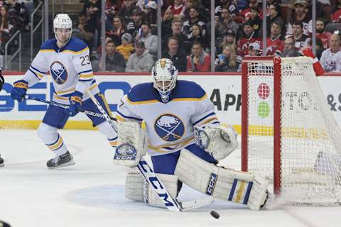 Apr 11, 2023; Newark, New Jersey, USA; Buffalo Sabres goaltender Devon Levi (27) makes a save in front of defenseman Mattias Samuelsson (23) during the first period against the New Jersey Devils at Prudential Center. Mandatory Credit: Vincent Carchietta-USA TODAY Sports