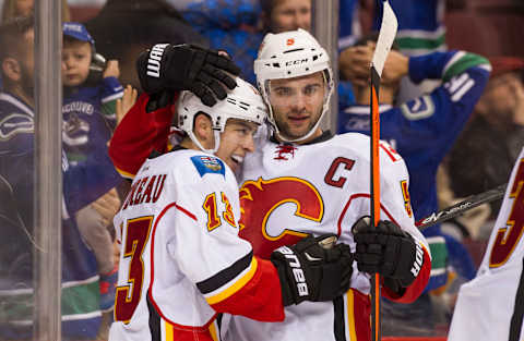 VANCOUVER, BC – OCTOBER 10: Johnny Gaudreau #13 of the Calgary Flames is congratulated by Mark Giordano #5 after scoring the game winning goal in overtime against the Vancouver Canucks in NHL action on October, 10, 2015 at Rogers Arena in Vancouver, British Columbia, Canada. (Photo by Rich Lam/Getty Images)