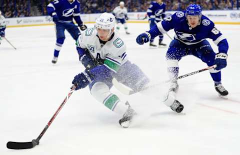 TAMPA, FLORIDA – JANUARY 07: Antoine Roussel #26 of the Vancouver Canucks and Mitchell Stephens #67 of the Tampa Bay Lightning fights for the puck during a game at Amalie Arena on January 07, 2020 in Tampa, Florida. (Photo by Mike Ehrmann/Getty Images)