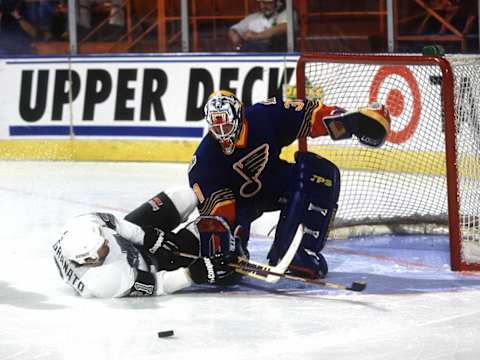 2000 Season: Curtis Joseph of the St. Louis Blues makes the save despite Tony Granato’s aggressive effort. (Photo by Wen Roberts/Getty Images)