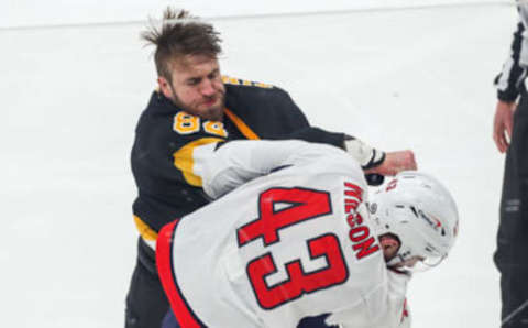 Mar 5, 2021; Boston, Massachusetts, USA; Boston Bruins defenseman Jarred Tinordi (84) punches Washington Capitals right wing Tom Wilson (43) during the second period at TD Garden. Mandatory Credit: Paul Rutherford-USA TODAY Sports