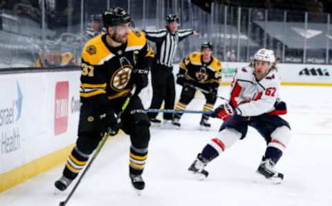 Apr 11, 2021; Boston, Massachusetts, USA; Washington Capitals left wing Carl Hagelin (62) defends Boston Bruins center Patrice Bergeron (37) at TD Garden. Mandatory Credit: Paul Rutherford-USA TODAY Sports