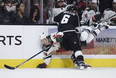 Oct 16, 2015; Los Angeles, CA, USA; Minnesota Wild left wing Jason Zucker (back) is knocked down by Los Angeles Kings center Jake Muzzin (6) during the second period at Staples Center. Mandatory Credit: Kelvin Kuo-USA TODAY Sports