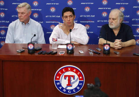 Texas Rangers owners Ray Davis, left, and Bob Simpson, right, flank President of Baseball Operations and General Manager Jon Daniels at a news conference at Globe Life Park in Arlington, Texas, on September 5, 2014. (Richard W. Rodriguez/Fort Worth Star-Telegram/TNS via Getty Images)