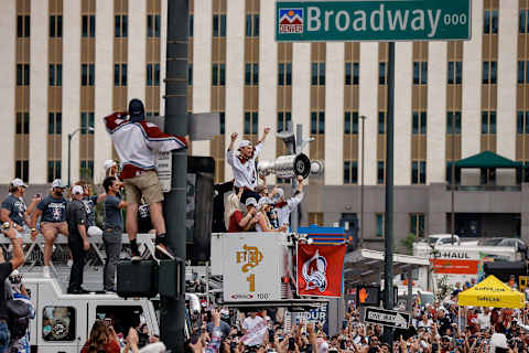 Jun 30, 2022; Denver, Colorado, USA; Colorado Avalanche payer Erik Johnson sits on the shoulders of teammate Gabriel Landeskog as Nathan MacKinnon hoists the Stanley Cup during the Stanley Cup celebration parade as it makes its way through downtown Denver towards Civic Center Park. Mandatory Credit: Isaiah J. Downing-USA TODAY Sports