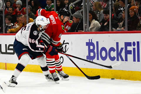 Dec 23, 2022; Chicago, Illinois, USA; Chicago Blackhawks defenseman Connor Murphy (5) and Columbus Blue Jackets right wing Kirill Marchenko (86) fight for the puck during the first period at the United Center. Mandatory Credit: Matt Marton-USA TODAY Sports