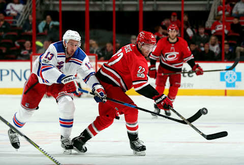 RALEIGH, NC – NOVEMBER 22: Brett Pesce #22 of the Carolina Hurricanes and Kevin Hayes #13 of the New York Rangers make an attempt at the puck during an NHL game on November 22, 2017 at PNC Arena in Raleigh, North Carolina. (Photo by Gregg Forwerck/NHLI via Getty Images)