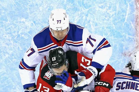 NEWARK, NEW JERSEY – APRIL 18: Nico Hischier #13 of the New Jersey Devils is held up by the New York Rangers during Game One in the First Round of the 2023 Stanley Cup Playoffs at the Prudential Center on April 18, 2023, in Newark, New Jersey. (Photo by Bruce Bennett/Getty Images)