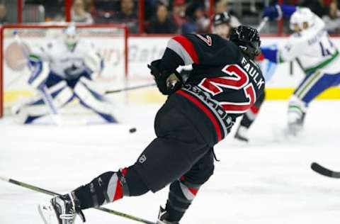 Jan 15, 2016; Raleigh, NC, USA; Carolina Hurricanes defensemen Justin Faulk (27) takes a shot against the Vancouver Canucks during the second period at PNC Arena. The Vancouver Canucks defeated the Carolina Hurricanes 3-2 in overtime. Mandatory Credit: James Guillory-USA TODAY Sports