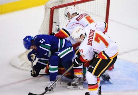 Dec 20, 2014; Vancouver, British Columbia, CAN; Calgary Flames defenseman Mark Giordano (5) and defenseman TJ Brodie (7) defend against Vancouver Canucks forward Derek Dorsett (51) during the third period at Rogers Arena. The Vancouver Canucks won 3-2 in overtime. Mandatory Credit: Anne-Marie Sorvin-USA TODAY Sports