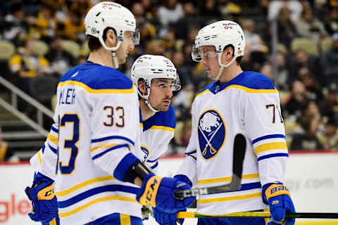 PITTSBURGH, PENNSYLVANIA – DECEMBER 17: Colin Miller #33, Brett Murray #57 and Victor Olofsson #71 of the Buffalo Sabres talk during the third period of a game against the Pittsburgh Penguins at PPG PAINTS Arena on December 17, 2021 in Pittsburgh, Pennsylvania. (Photo by Emilee Chinn/Getty Images)