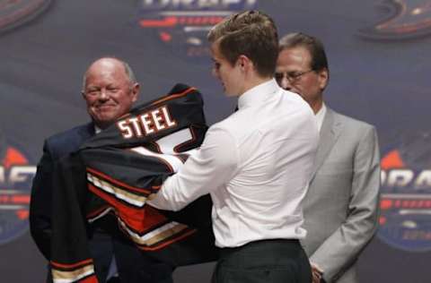 CHL Player Rankings: Sam Steel puts on a team jersey after being selected as the number thirty overall draft pick by the Anaheim Ducks in the first round of the 2016 NHL Draft at the First Niagra Center. Mandatory Credit: Timothy T. Ludwig-USA TODAY Sports