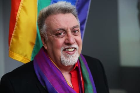 Rainbow Flag creator Gilbert Baker poses at the Museum of Modern Art (MoMA) in January 2016 in New York City.