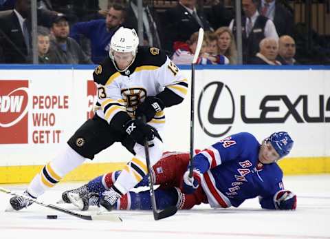 NEW YORK, NEW YORK – OCTOBER 27: Charlie Coyle #13 of the Boston Bruins moves the puck past Kaapo Kakko #24 of the New York Rangers during the first period at Madison Square Garden on October 27, 2019 in New York City. (Photo by Bruce Bennett/Getty Images)