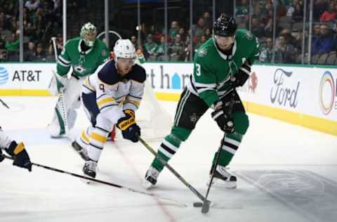 DALLAS, TEXAS – JANUARY 30: John Klingberg #3 of the Dallas Stars skates the puck against Jack Eichel #9 of the Buffalo Sabres at American Airlines Center on January 30, 2019 in Dallas, Texas. (Photo by Ronald Martinez/Getty Images)