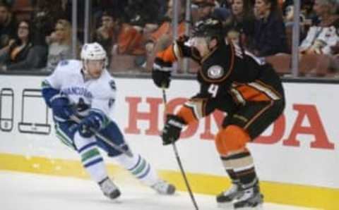 October 23, 2016; Anaheim, CA, USA; Anaheim Ducks defenseman Cam Fowler (4) clears the puck against the defense of Vancouver Canucks left wing Sven Baertschi (47) during the first period at Honda Center. Mandatory Credit: Gary A. Vasquez-USA TODAY Sports