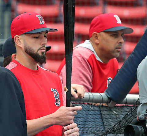 BOSTON – MAY 16: Boston Red Sox utility player Blake Swihart, left, waits for his turn in the cage during batting practice before the start of the game. Manager Alex Cora is in the background at right. The Boston Red Sox host the Oakland Athletics in a regular season MLB baseball game at Fenway Park in Boston on May 16, 2018. (Photo by Jim Davis/The Boston Globe via Getty Images)