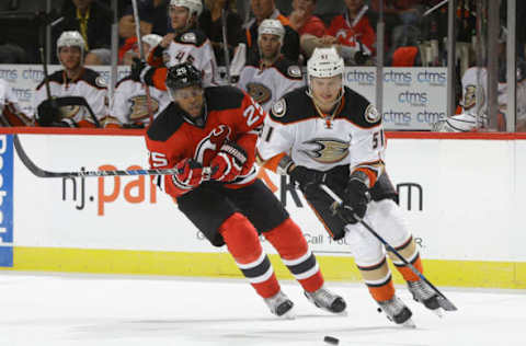 NEWARK, NJ: Jacob Larsson #51 of the Anaheim Ducks and Devante Smith-Pelley #25 of the New Jersey Devils pursue a loose puck on October 18, 2016. (Photo by Andy Marlin/NHLI via Getty Images)