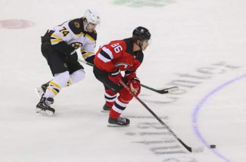 Jan 14, 2021; Newark, New Jersey, USA; New Jersey Devils center Jack Hughes (86) skates with the puck while being defended by Boston Bruins left wing Jake DeBrusk (74) during overtime at Prudential Center. Mandatory Credit: Ed Mulholland-USA TODAY Sports