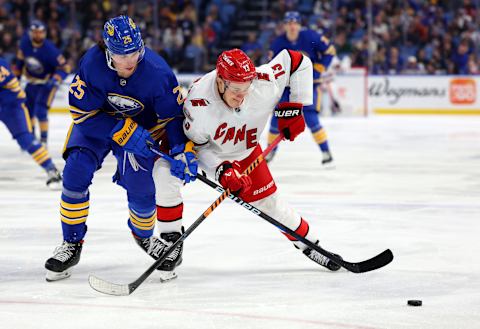 Apr 8, 2023; Buffalo, New York, USA; Buffalo Sabres defenseman Owen Power (25) and Carolina Hurricanes right wing Jesse Puljujarvi (13) go after a loose puck during the third period at KeyBank Center. Mandatory Credit: Timothy T. Ludwig-USA TODAY Sports