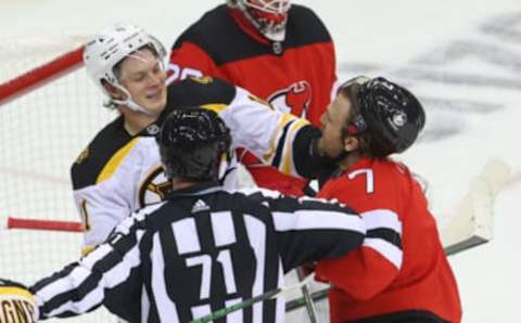 Jan 14, 2021; Newark, New Jersey, USA; Boston Bruins center Trent Frederic (11) and New Jersey Devils defenseman Matt Tennyson (7) push and shove during the second period at Prudential Center. Mandatory Credit: Ed Mulholland-USA TODAY Sports