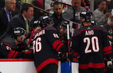 May 20, 2022; Raleigh, North Carolina, USA; Carolina Hurricanes head coach Rod Brind’Amour talks to left wing Teuvo Teravainen (86) and center Sebastian Aho (20) during the game against the New York Rangers during the third period in game two of the second round of the 2022 Stanley Cup Playoffs at PNC Arena. Mandatory Credit: James Guillory-USA TODAY Sports