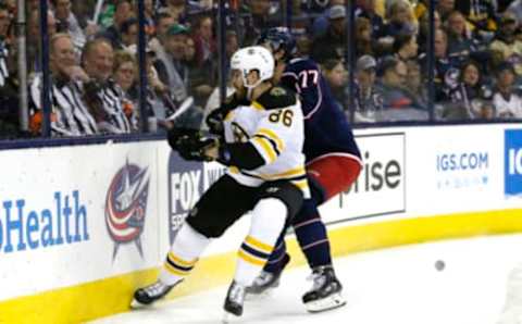 Apr 2, 2019; Columbus, OH, USA; Boston Bruins defenseman Kevan Miller (86) chips the puck away from Columbus Blue Jackets right wing Josh Anderson (77) during the second period at Nationwide Arena. Mandatory Credit: Russell LaBounty-USA TODAY Sports