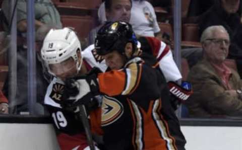 Oct 14, 2015; Anaheim, CA, USA; Arizona Coyotes right wing Shane Doan (19) and Anaheim Ducks defenseman Kevin Bieksa (2) reach for the puck at Honda Center. Mandatory Credit: Kirby Lee-USA TODAY Sports